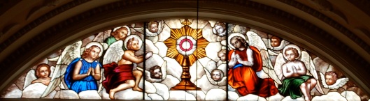 Eucharist stained glass window behind altar